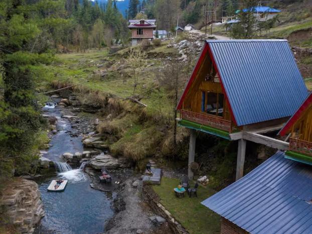 an aerial view of a river with a house at The Riverbank Nest in Jibhi