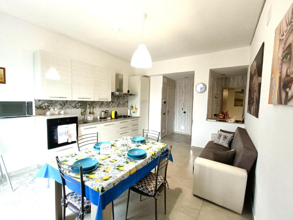 a kitchen and living room with a blue table and chairs at Scirocco Blu - Casa al Mare in Donnalucata