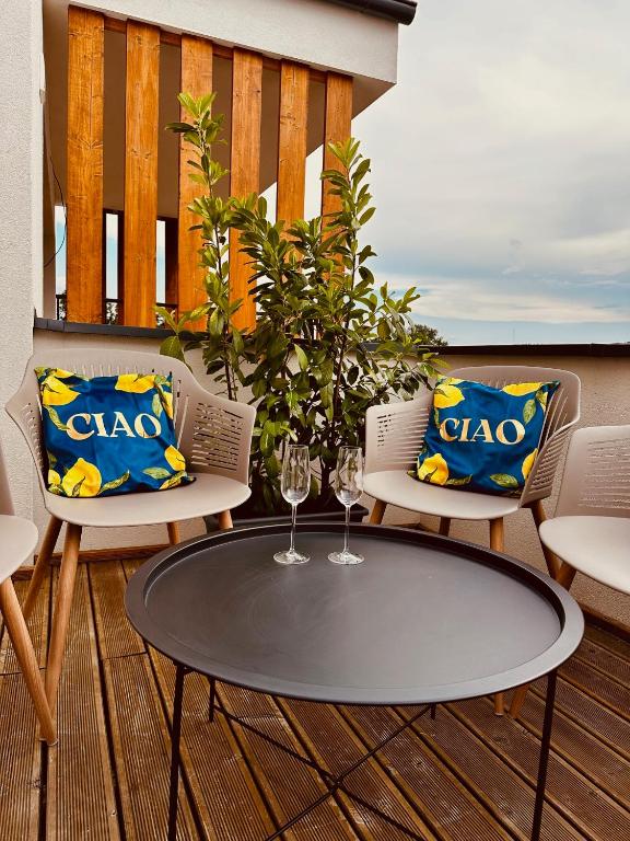 a table and two chairs on a deck with a table at SILVER apartment - Rezidencia Bojnice in Bojnice