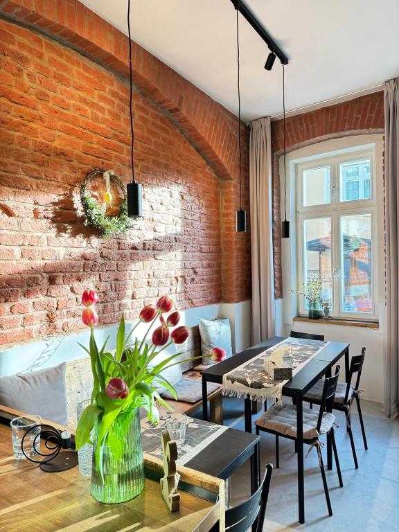 una camera con un muro di mattoni e un tavolo con sedie di FOUR ROOMS Carlsbad Authentic a Karlovy Vary