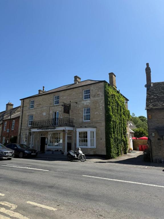 a man sitting on a motorcycle in front of a building at The Market Tavern in Bampton