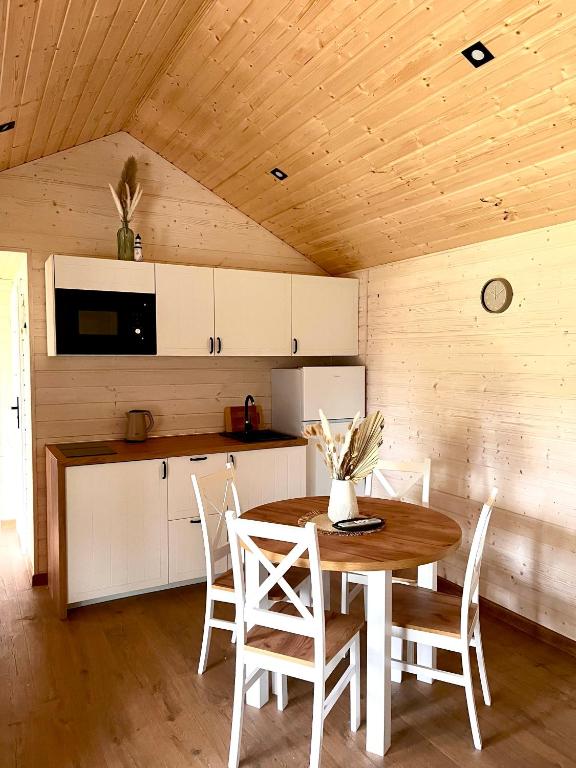 kuchnia ze stołem i krzesłami w pokoju w obiekcie Holiday Resort Zakątek Łeba w Łebie