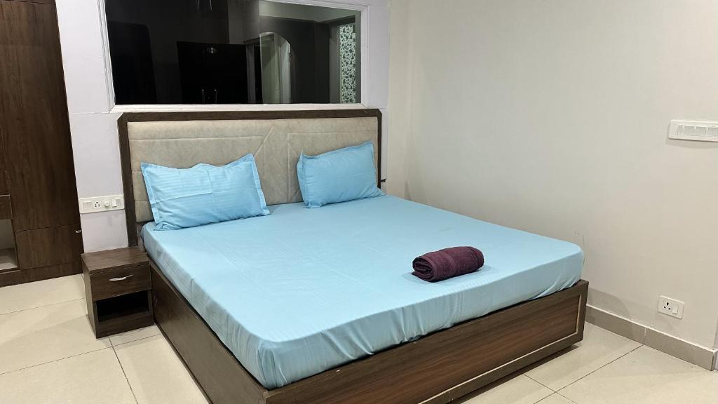 a bed with blue sheets and blue pillows at LivingStone Sky Hills Apartment Kasauli in Kasauli