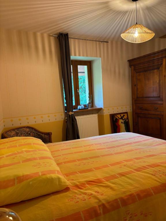 une chambre avec un grand lit avec une couverture jaune dans l'établissement la maison de la Felicidad, à Boussy