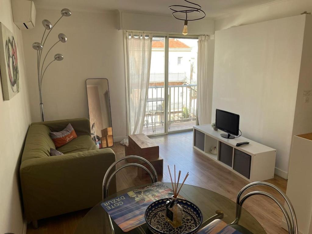 un salon avec un canapé et une télévision dans l'établissement Seaside Retreat, à Nice