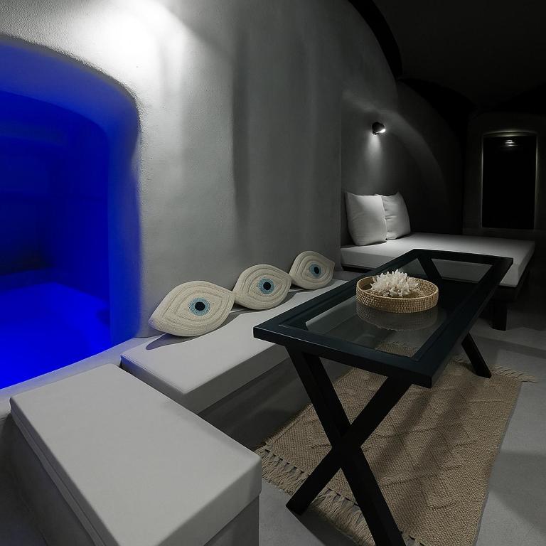 a room with a table and a bed and a room with a couch at Selora Cave in Pyrgos