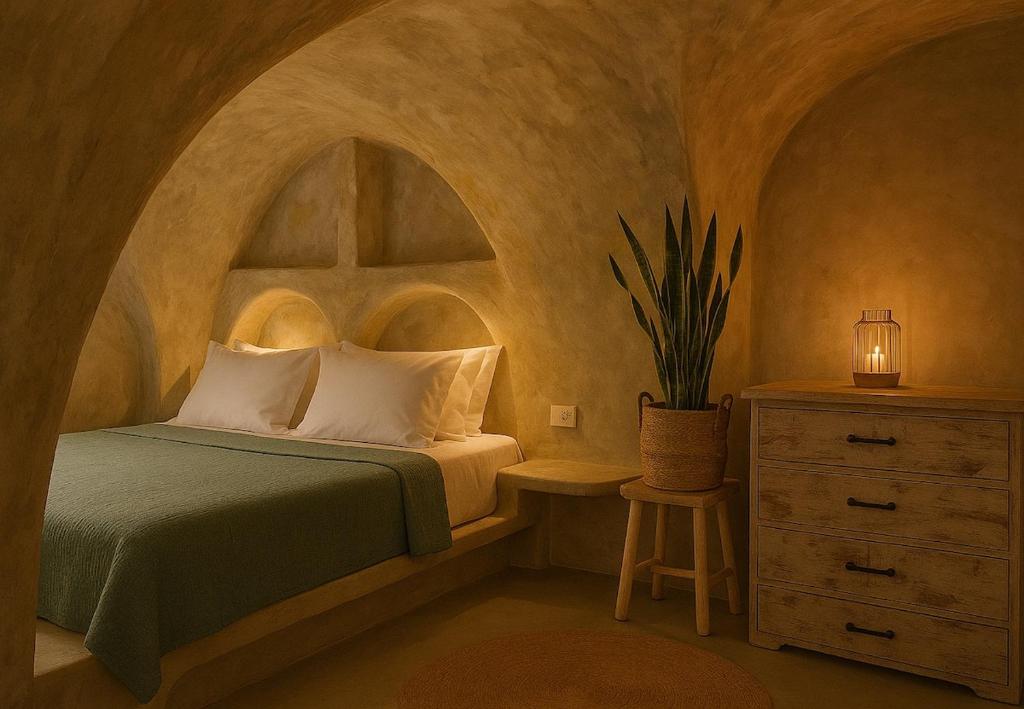 a bedroom with a bed and a dresser with a lamp at Selora Cave in Pirgos