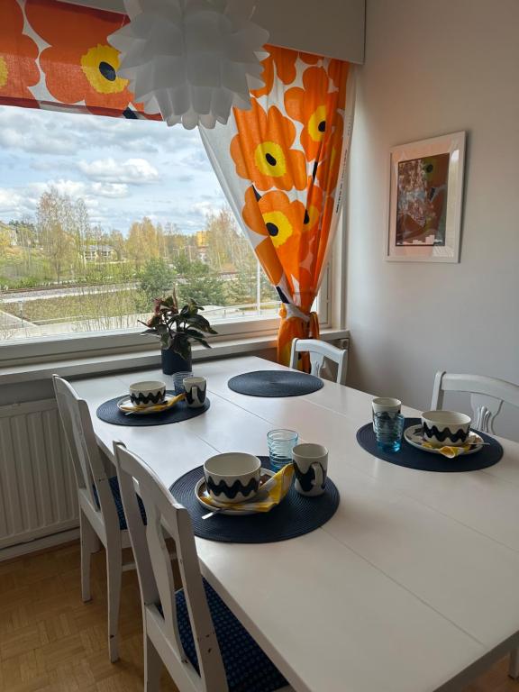 a dining room table with plates and cups on it at Rantaraitti in Savonlinna