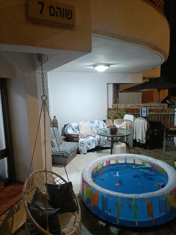 a room with a swing and a living room at Amdar Village Cottage עם ממ"ד in Eilat