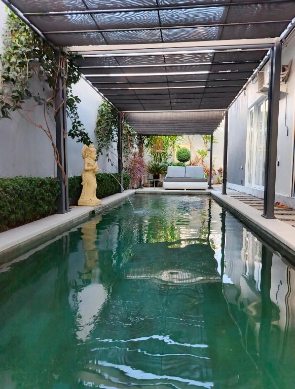 a swimming pool with green water in a house at Aroha Villa in Banjar