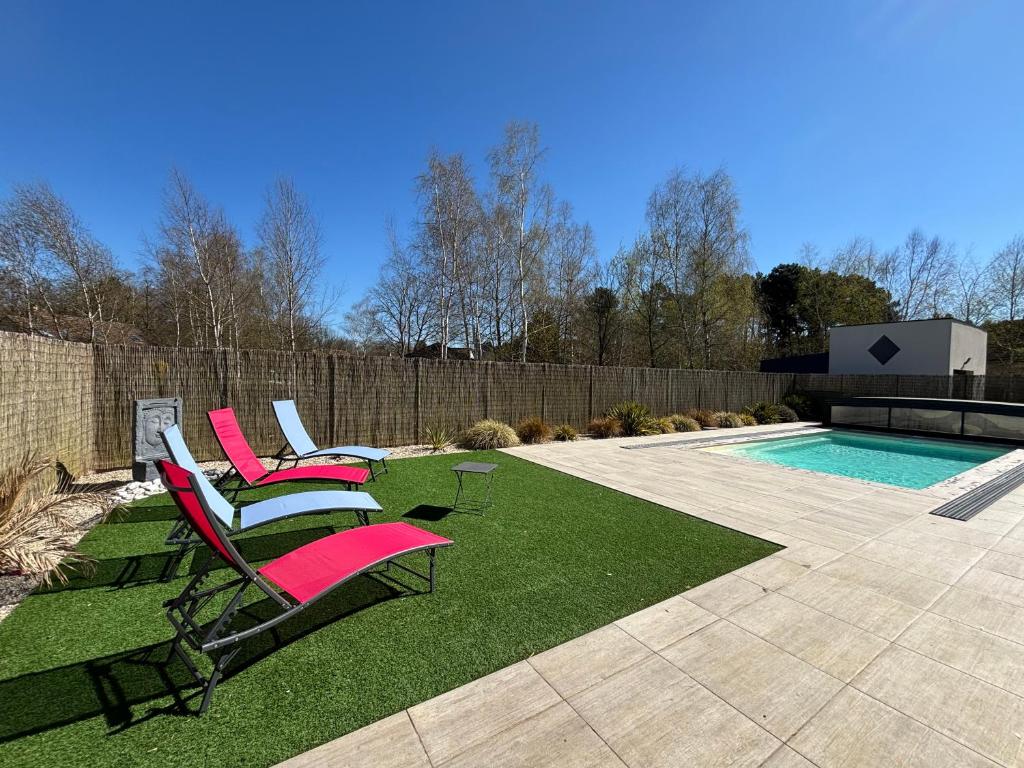 un groupe de chaises assises à côté d'une piscine dans l'établissement Gîte à la campagne 4, à Cérans-Foulletourte