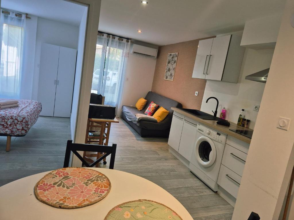 une cuisine et un salon avec un canapé et une table dans l'établissement Appart T2, Résidence Charles Trenet, à Narbonne