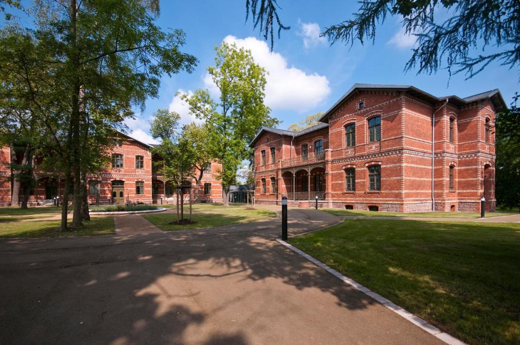 un grand bâtiment en briques sur un campus dans l'établissement Boardinghaus Weinberg Campus, à Halle-sur-Saale