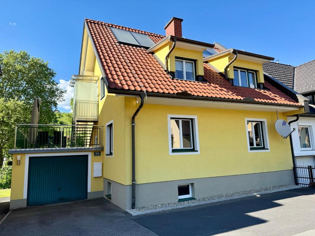 a yellow house with a red roof at Haus Am Fluss in Deutschlandsberg
