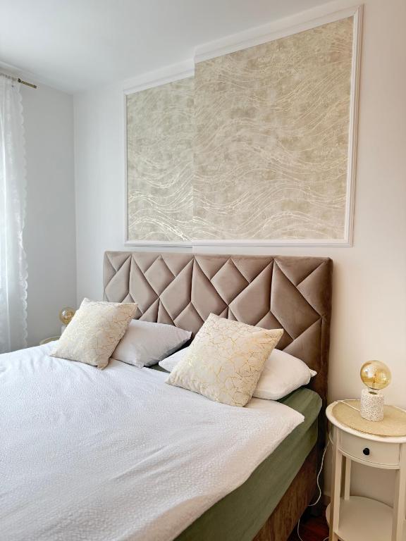 a bedroom with a large bed with white sheets and pillows at Cozy Flat near Airport & Sarajevo Center, Free Parking in Sarajevo