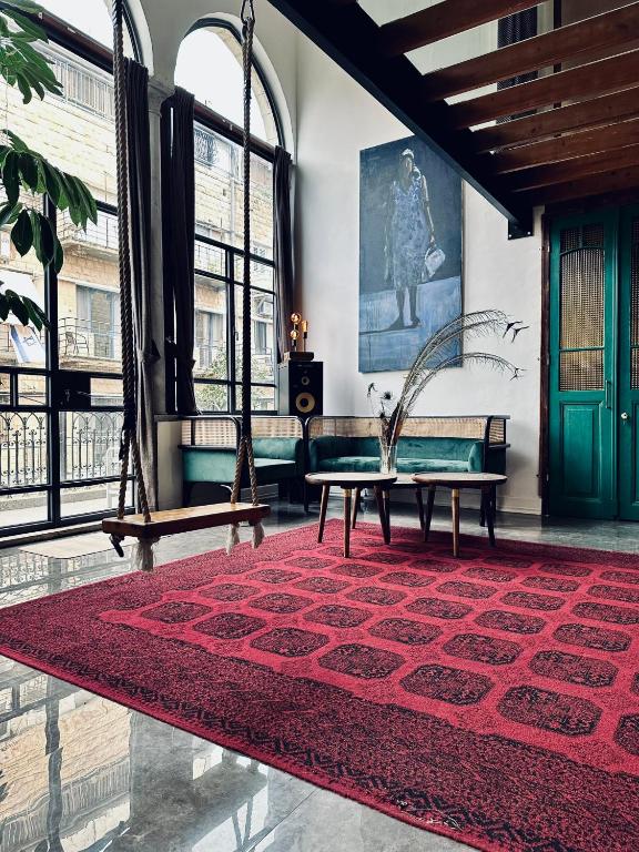 a living room with a red rug and a couch at otto7senses in Haifa