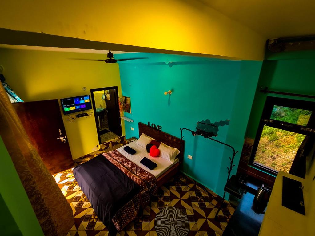 een slaapkamer met een bed in een kamer met groene muren bij The Rawscape hostel in Kausani