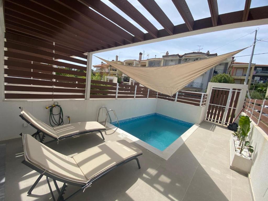 a patio with a hammock and a swimming pool at Summer Stories Kallithea in Kallithea Halkidikis