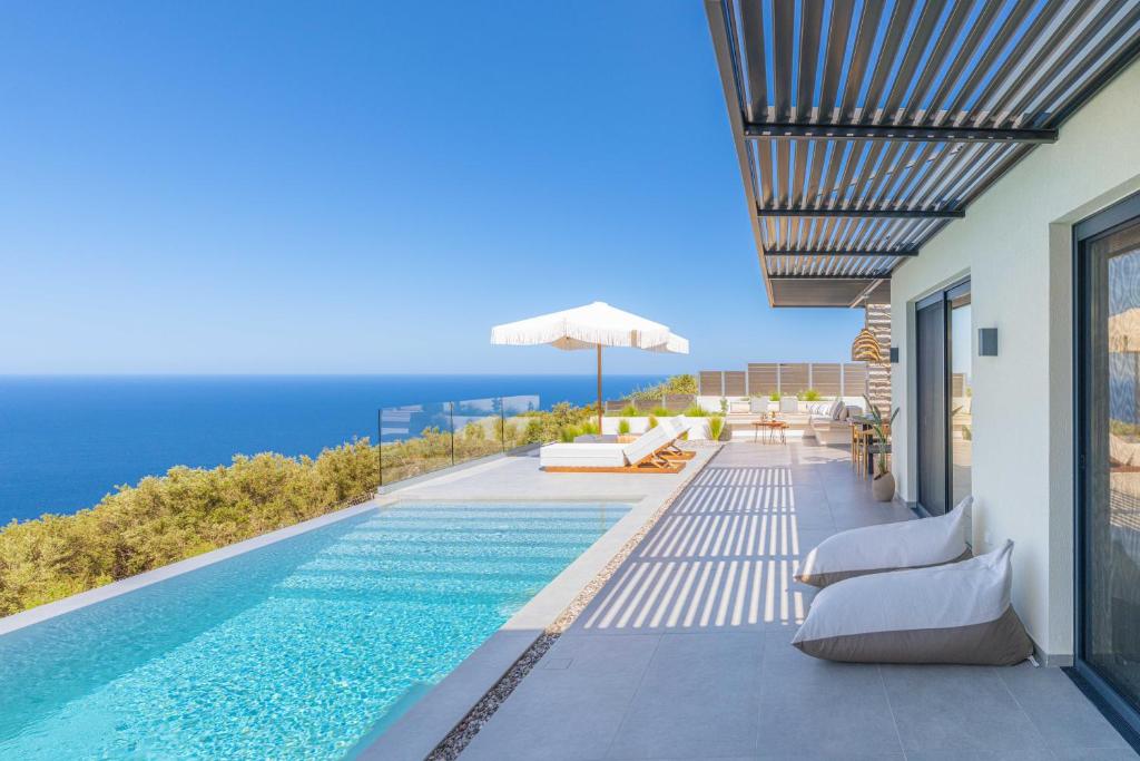 a swimming pool on the side of a house at Nimbus Villas Lefkada in Kalamitsi