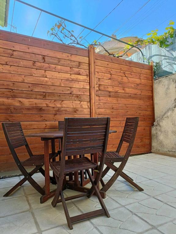 une table en bois et deux chaises à côté d'une clôture dans l'établissement Appartement studio, à Nice