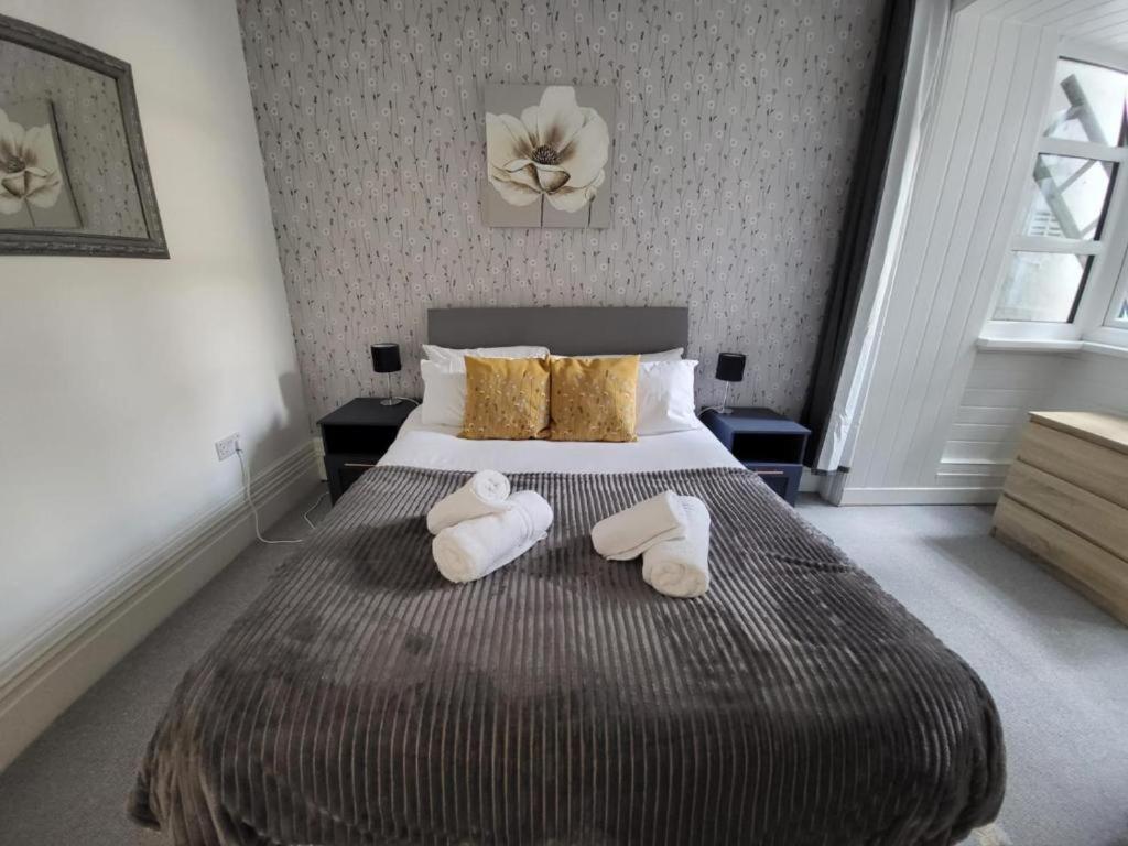 a bedroom with a bed with two towels on it at 2 bed flat sleeps 4 Swansea centre in Swansea