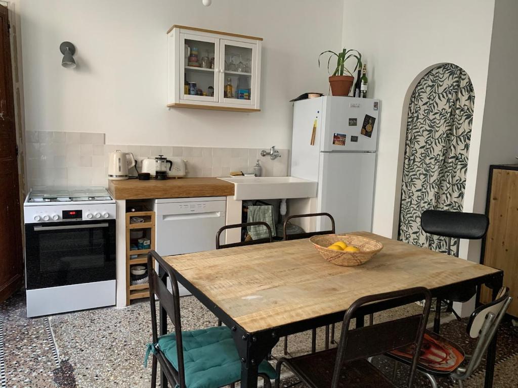 une cuisine avec une table en bois et une table et des chaises dans l'établissement Grand appartement centre historique, à Arles