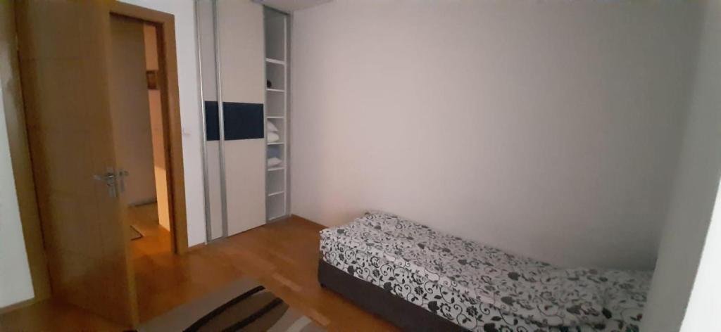 une petite chambre avec un lit et une porte dans l'établissement شقة في اليجا appartment in Ilidza Sarajevo, à Sarajevo