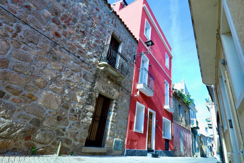 a red building on the side of a street at Spacious Modern Fully equipped Apartment in Monumental Building - Parking - Historical Centre in Olbia
