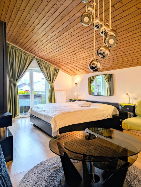 a bedroom with a large bed and a table at Garden Apartments Janša in Radovljica