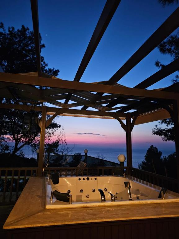 a wooden gazebo with two cats in a bath tub at Sapolto Villas Faralya in Fethiye