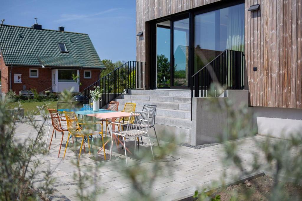 un patio avec une table et des chaises et un bâtiment dans l'établissement Luxus-Ferienhaus DS11, à Fehmarn