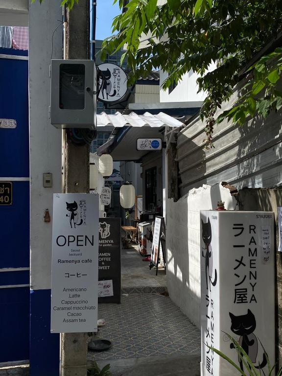 a street with signs on a pole in front of a building at Cat in the box homestay in Godown