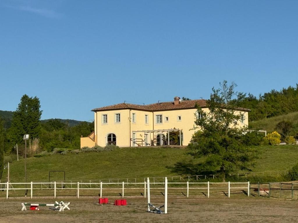 dom na szczycie wzgórza z płotem w obiekcie Agriturismo In Campagna w mieście Santa Fiora