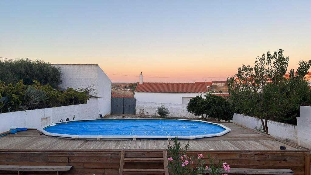 a swimming pool on top of a wooden deck at Casa da Aldeia in Moura