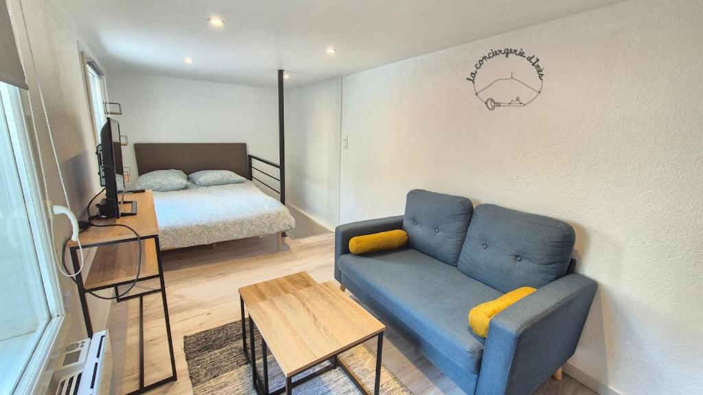 - un salon avec un canapé bleu et un lit dans l'établissement Le Saint Benoît #Confort, à Clermont-Ferrand