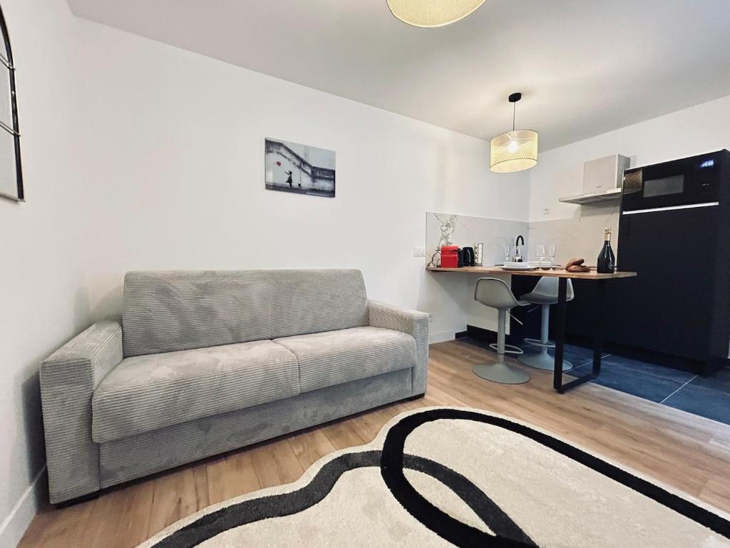 un salon avec un canapé et une table dans l'établissement 4 clairmarais T2 chic et cocooning proche centre, à Reims