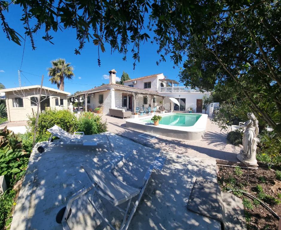 an exterior view of a house with a swimming pool at Casa Papaver Relax Appartement in Coín