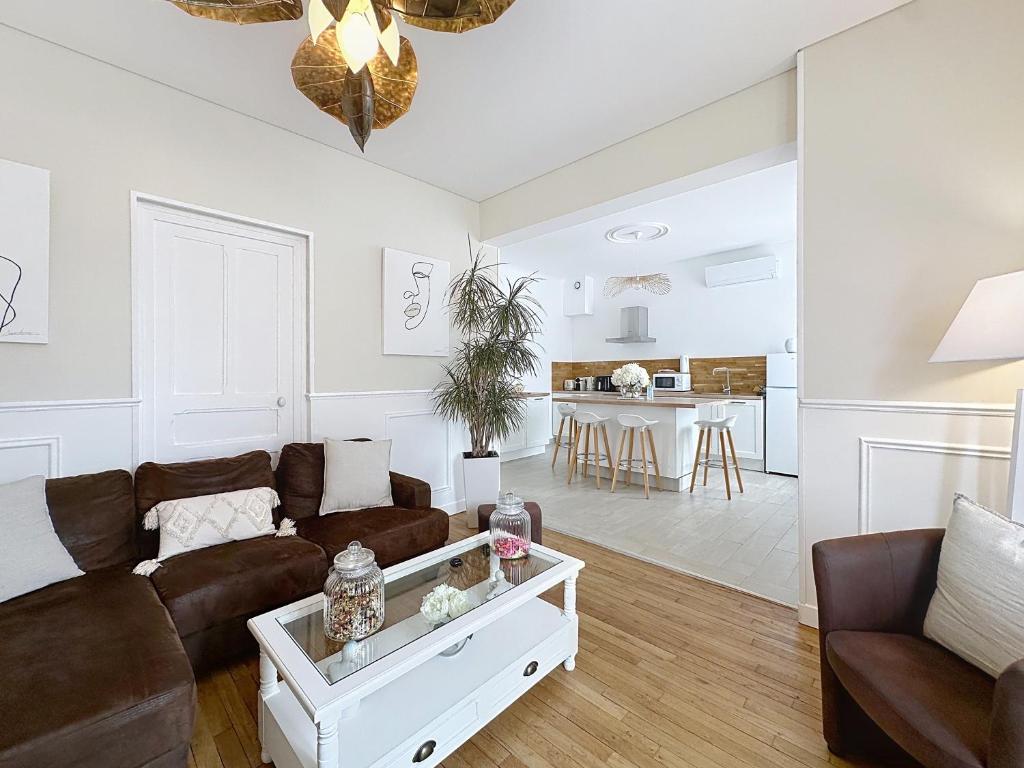 una sala de estar con un sofá y una mesa en Charmante maison 2 chambres avec cour et jardin, en Sainte-Savine
