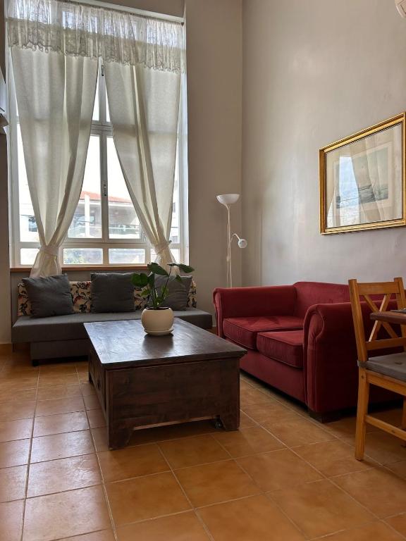 a living room with a red couch and a coffee table at Your Home in Mevasseret Zion in Mashabbe Sade