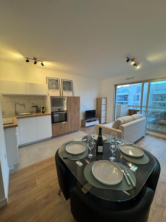 Il comprend un grand salon avec une table et une cuisine. dans l'établissement Fully renovated studio, steps from beach with a sunny terrace and free wifi, à Antibes