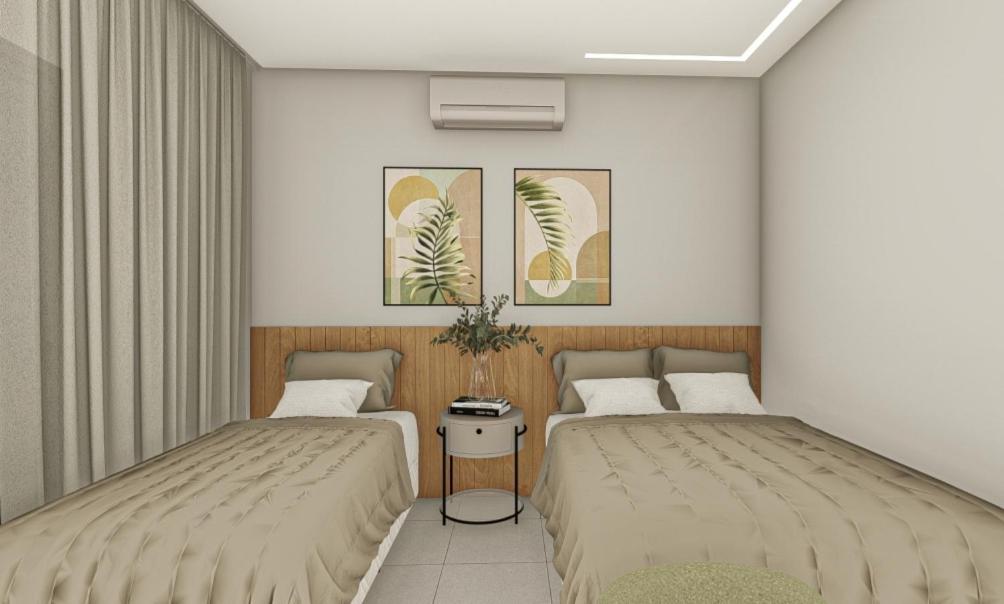 two beds sitting next to each other in a room at Pousada Miray Olímpia in Olímpia