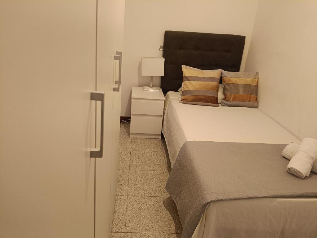 Un dormitorio con dos camas y una mesita de noche con lámpara. en Habitación individual acogedora, en Barcelona