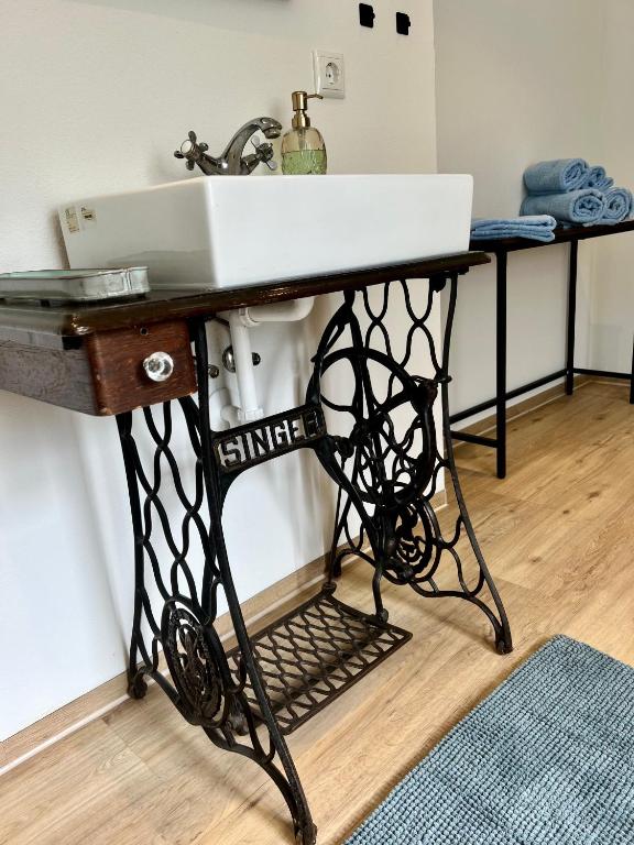 a bathroom sink on a iron stand with a sink on it at Wiesenau Apartments by Restaurant WIESENAU in Prerow