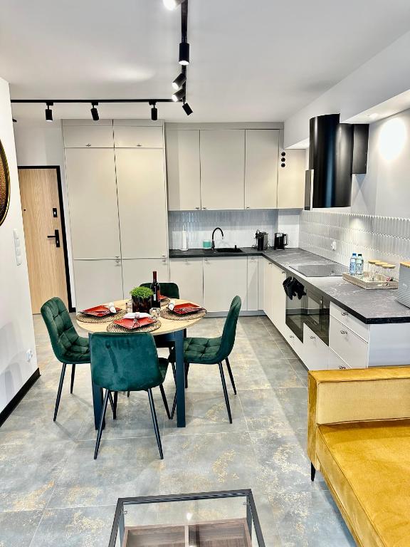 a kitchen with a table and chairs in a room at Apartament Modesta Przy Aquaparku Reda in Rumia