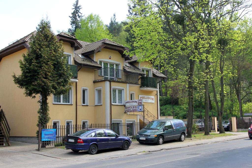 two cars parked in front of a house at Willa Preludium in Gdańsk