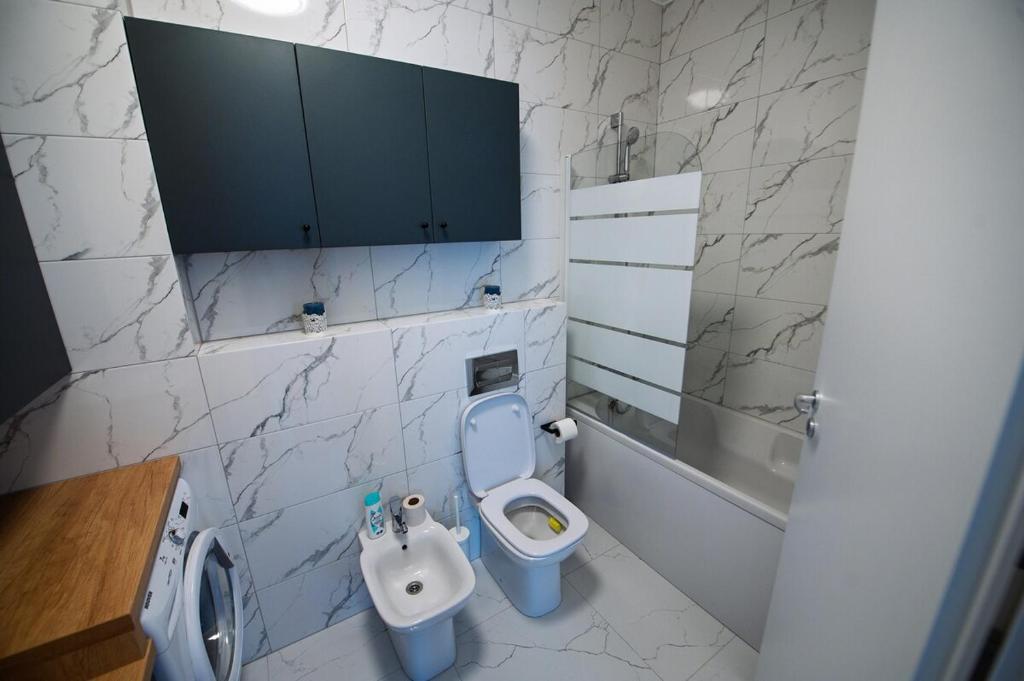 a bathroom with a toilet and a sink at Bruno Apartment in Arad