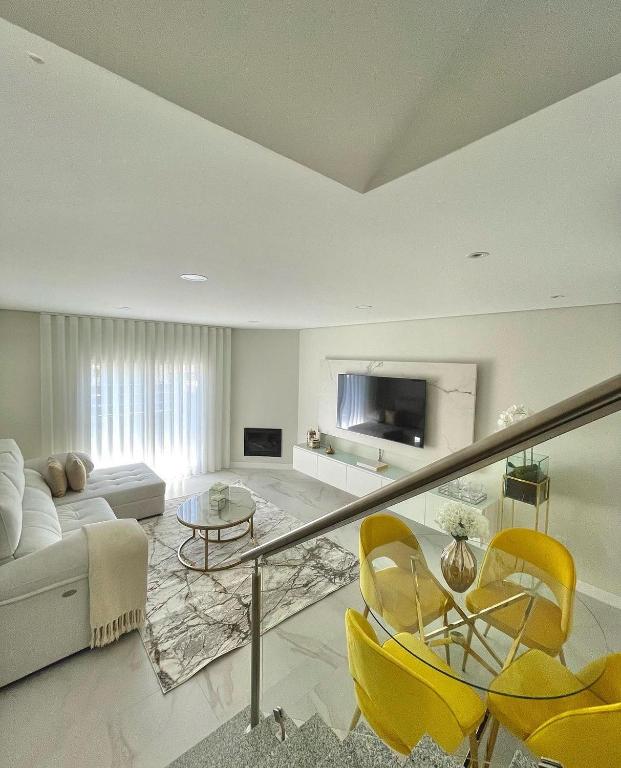 a living room with yellow chairs and a couch at homeSilvaSanches in Quinta do Conde