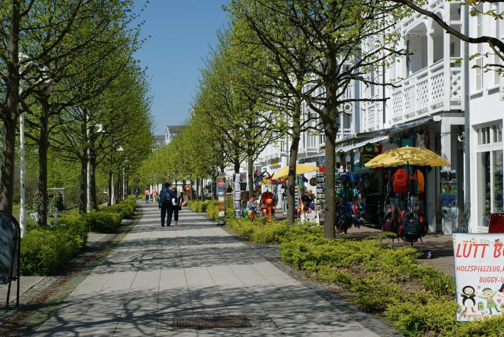 une personne marchant sur un trottoir dans une ville dans l'établissement Seeparkpromenade Sellin Wohnung Morgensonne, à Sellin