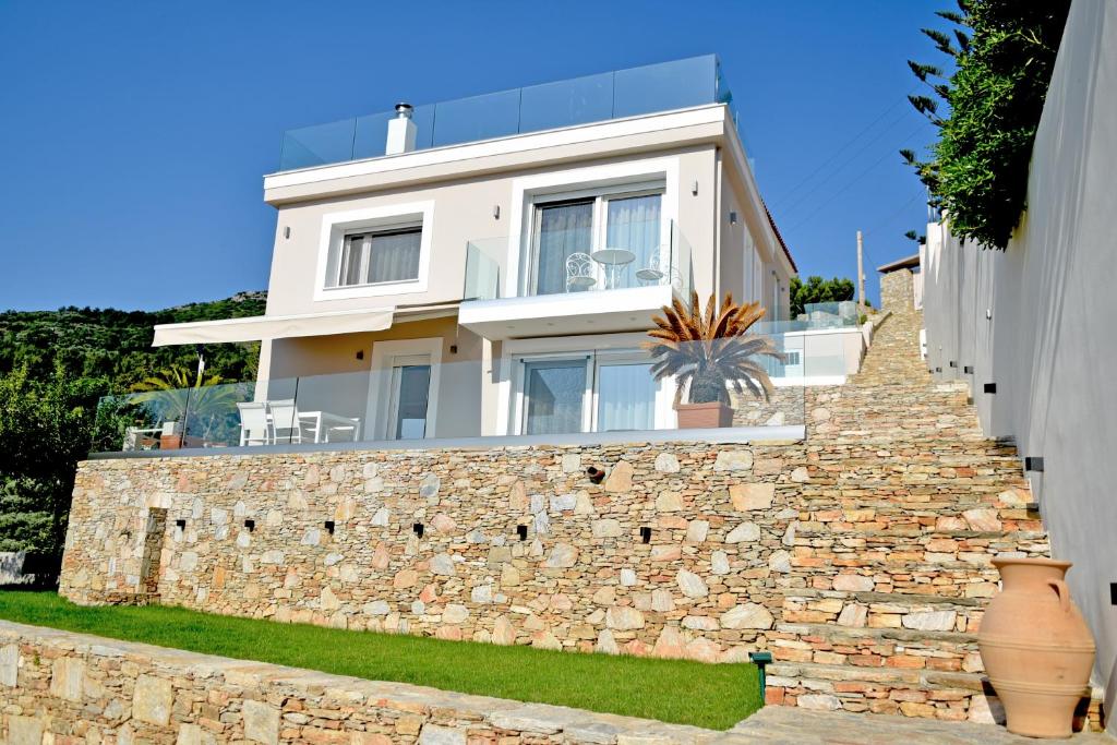 a white house on top of a stone wall at Samos Endless Blue in Samos
