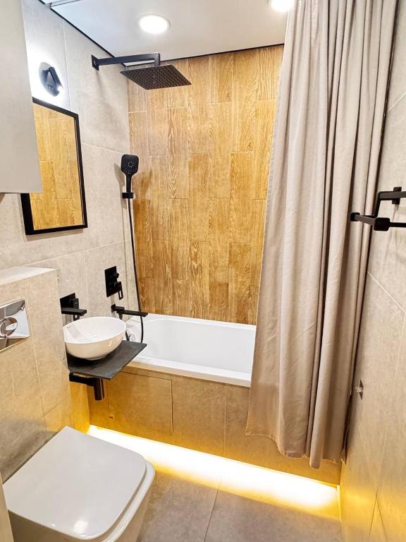 a bathroom with a tub and a toilet and a sink at 2 комнатная в историческом центре Наурызбай батыра 41 in Almaty